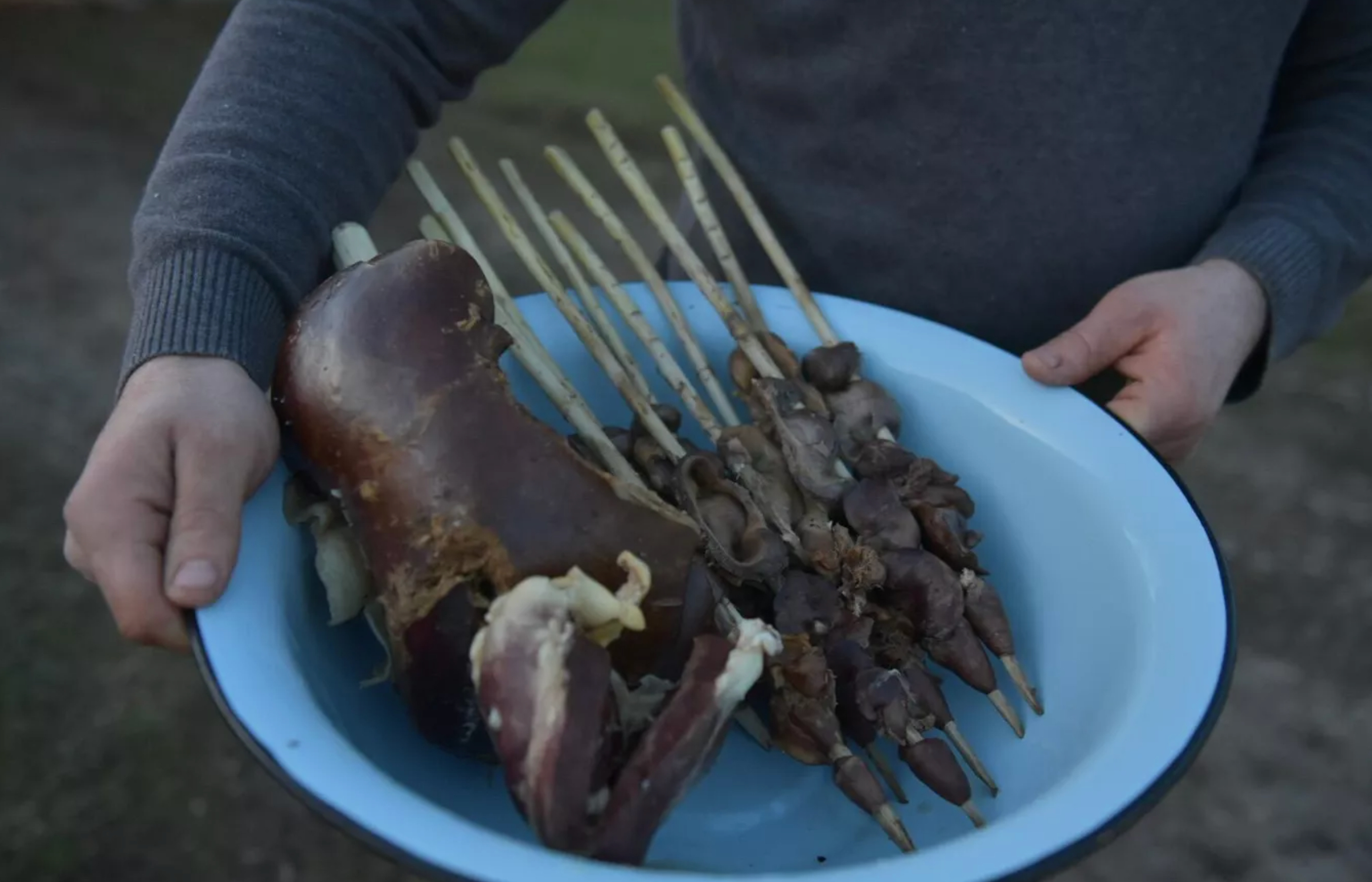 The heart and liver of the sacrificial animal are threaded onto walnut sticks.
