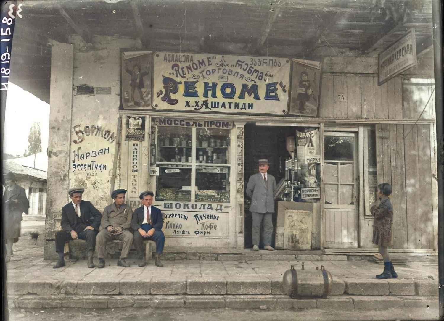 On the far left, smoking, is Nestor Lakoba; in the background is Saria Lakoba. Photo by Eugene Schilling. The scene shows the grocery and tobacco trade of Kharlampiy Khristoforovich Ashatidi, [Greek] “Renome”, located on Liberty Street (known as Lenin Street in Soviet times, and today as Leon Street), Sukhum, Abkhazia, 1929.
