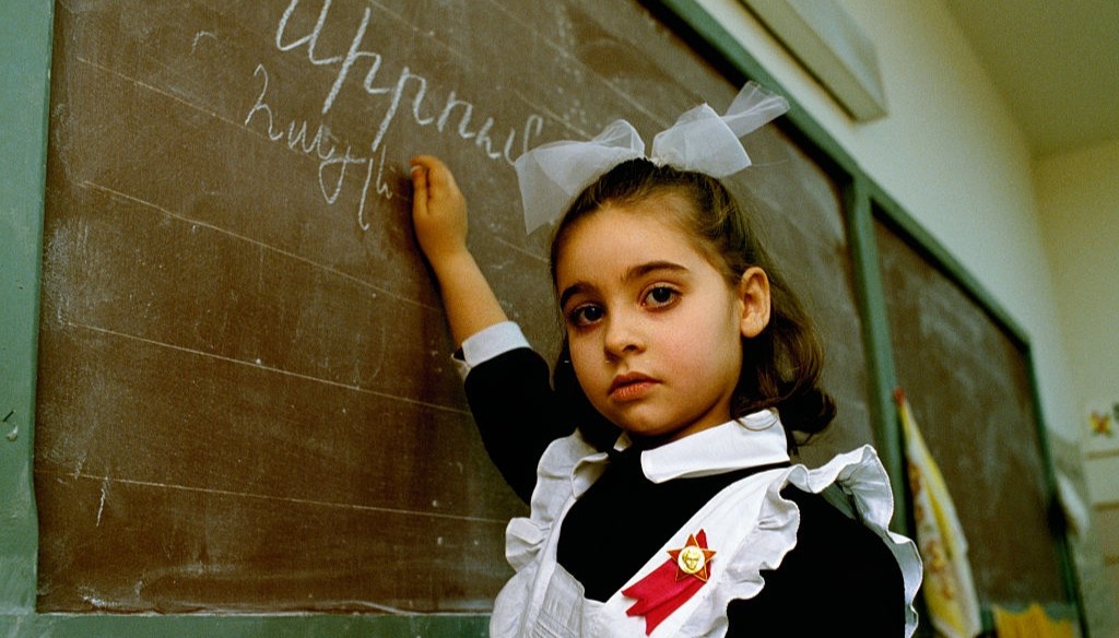 An Armenian girl writes on the chalkboard at school