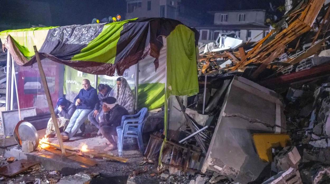 Survivors in a makeshift shelter amid the rubble in Hatay, Turkey. Photo: Bülent Kılıç/AFP
