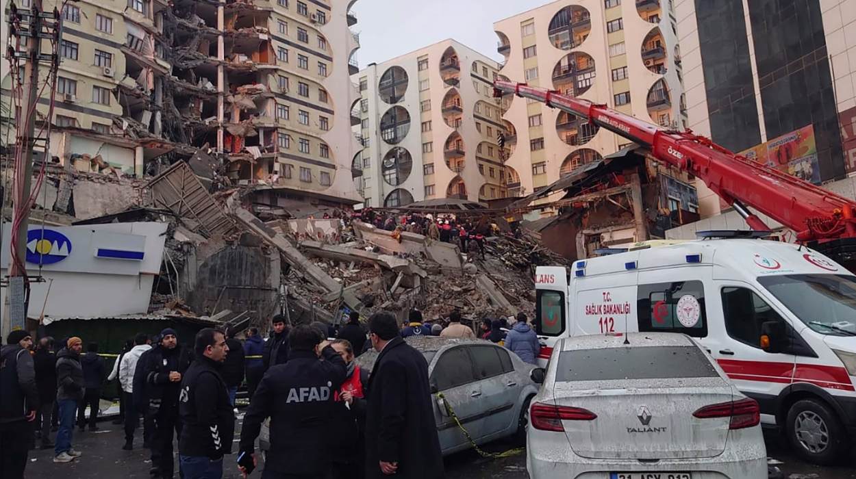 Rescue workers and medical teams try to reach trapped residents in a collapsed building following an earthquake in Diyarbakir, southeastern Turkey, early Monday